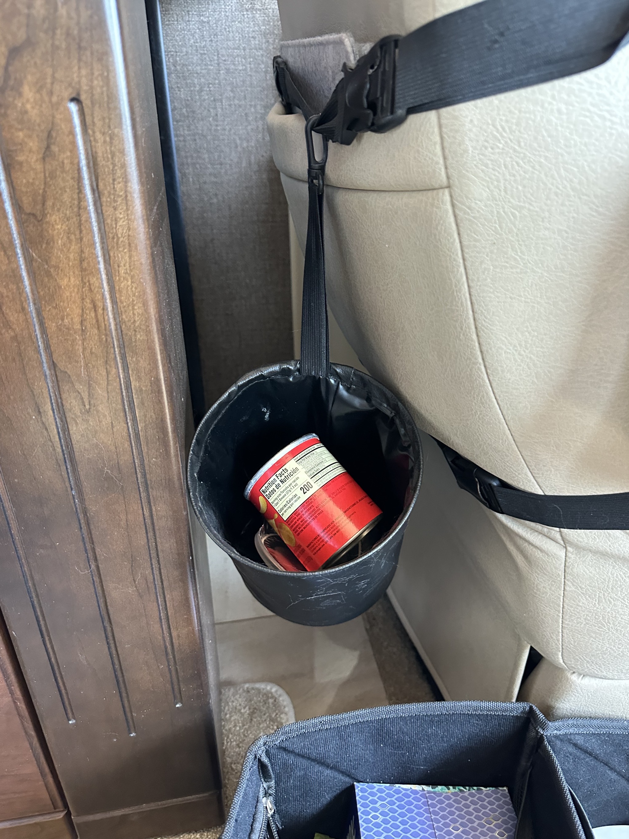 Garbage bin hanging on back of driver chair