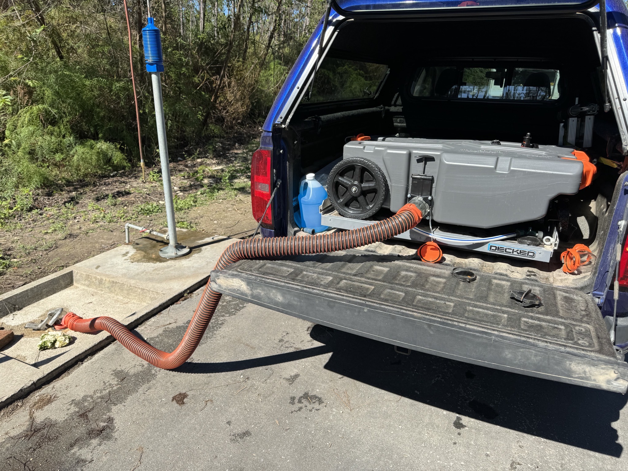 Tote tank in back of pickup, draining to dump station
