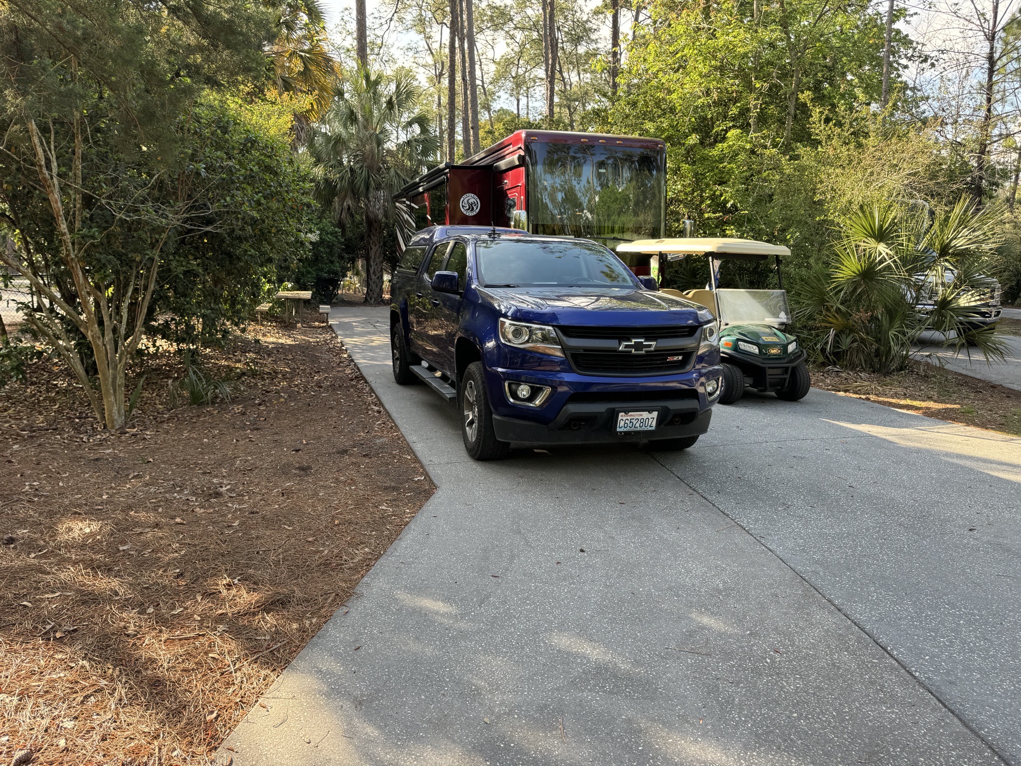 Motorhome, truck, golf cart in campsite