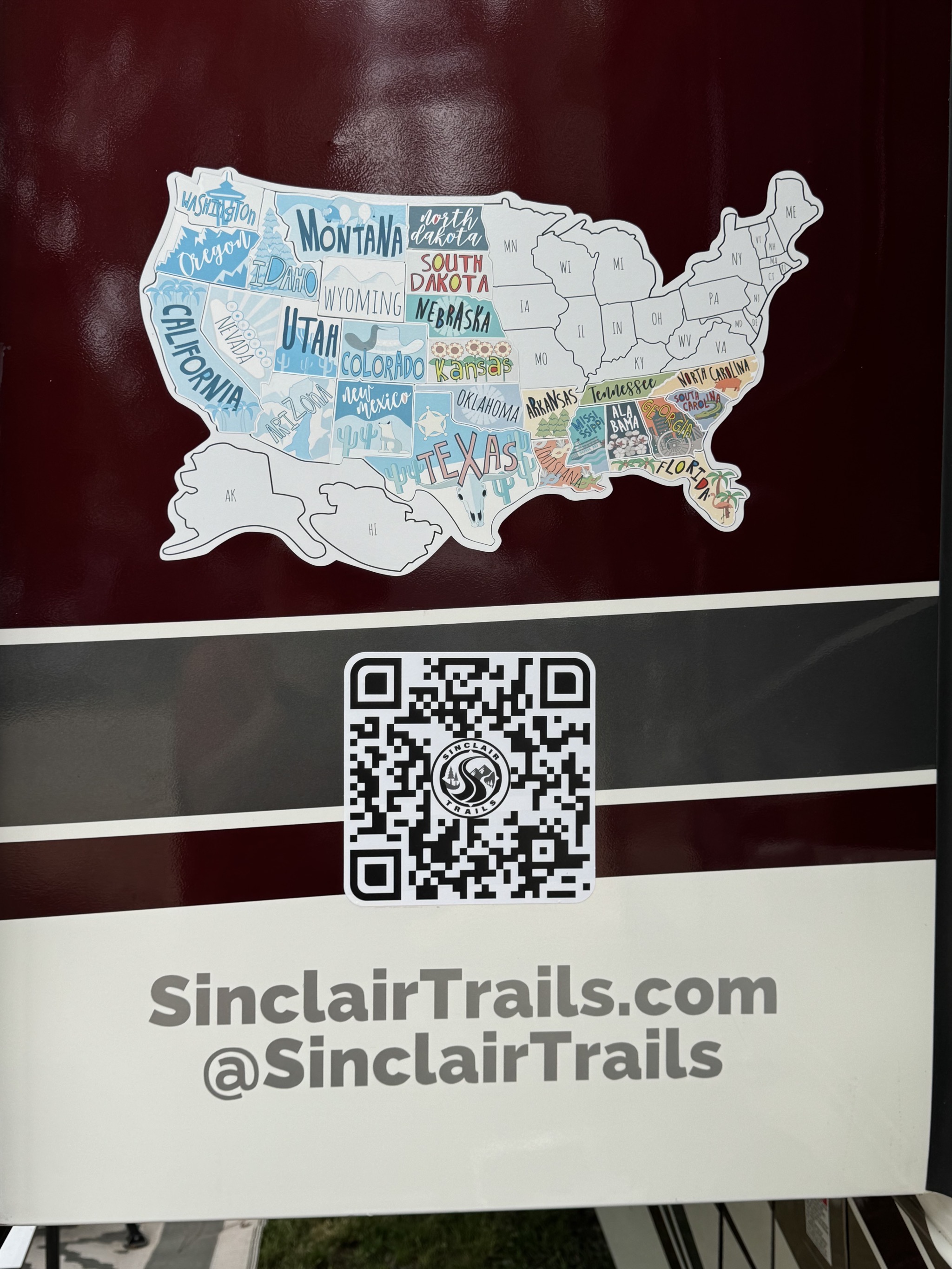 States map, QR code, and URL stickers on side of motorhome
